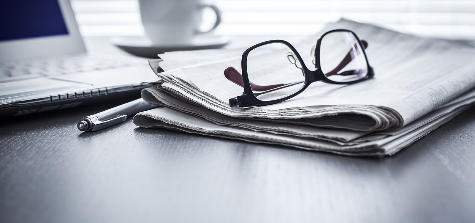 Pair of glasses on top of a newspaper
