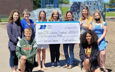 Kids holding a big check