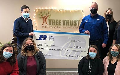 Tree Trust team and RCU team holding a big check