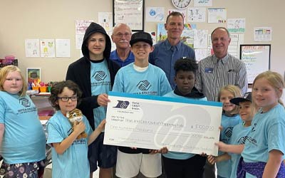Boys and Girls holding a big donation check