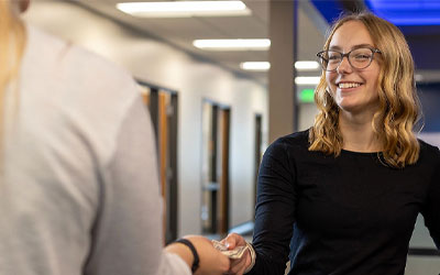 Young adult woman in at an RCU Office with a teller