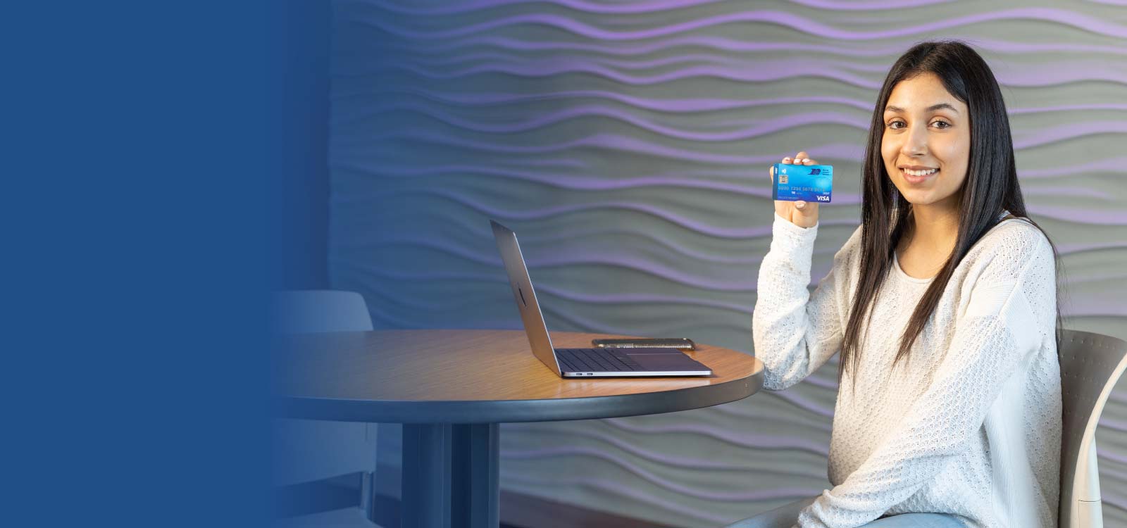 Image of a young womanman holding an RCU debit card