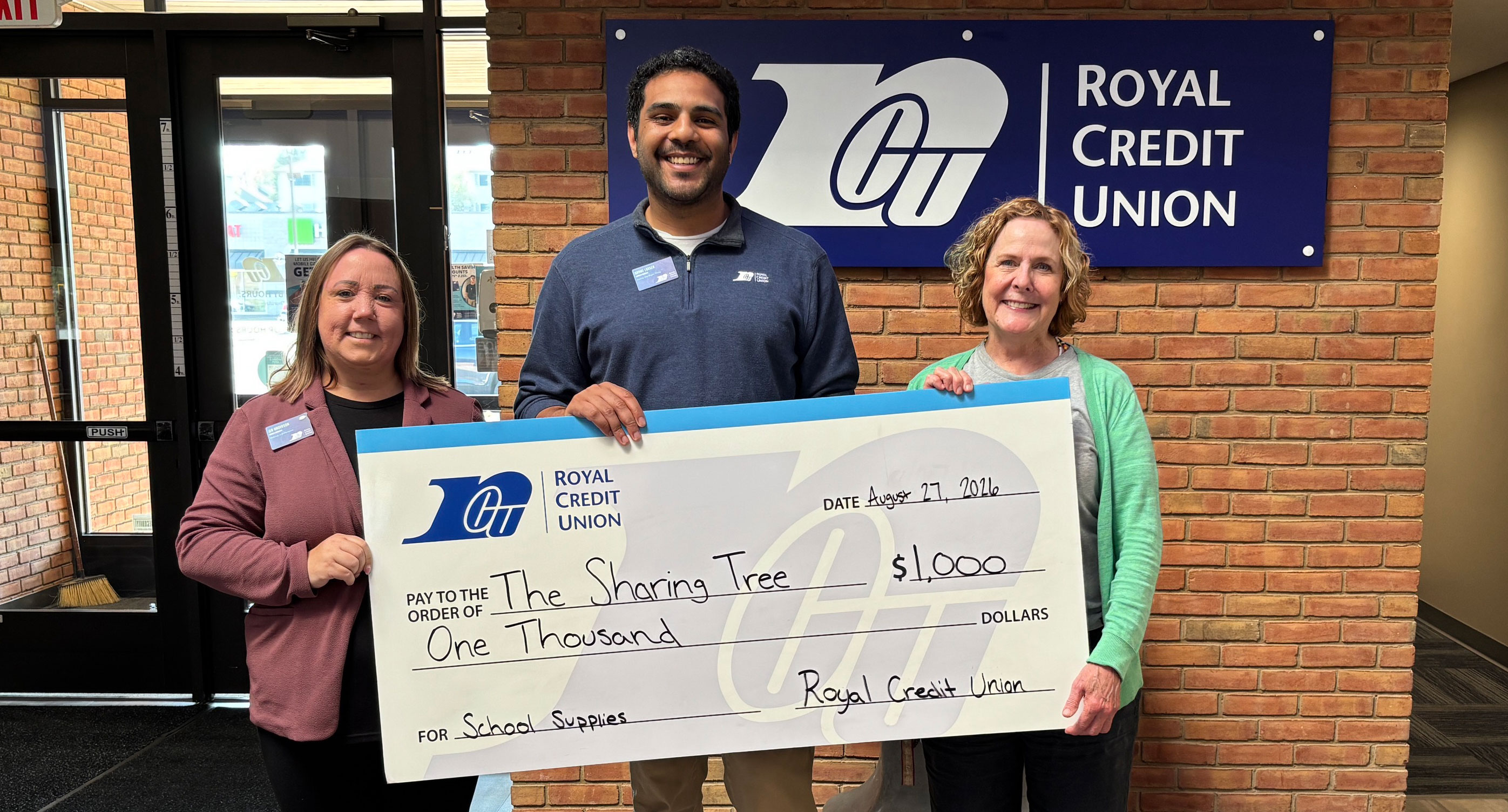 Group of Royal leaders holding a big check for $1,000