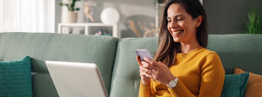 Woman sitting on couch with their laptop