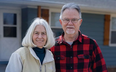 Husband and wife standing in the front yard