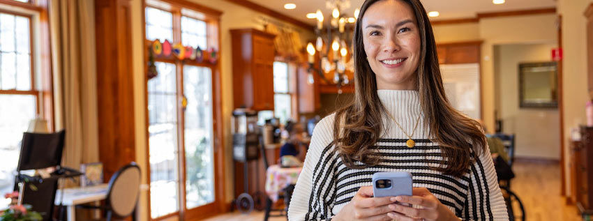 Member using her phone in her house