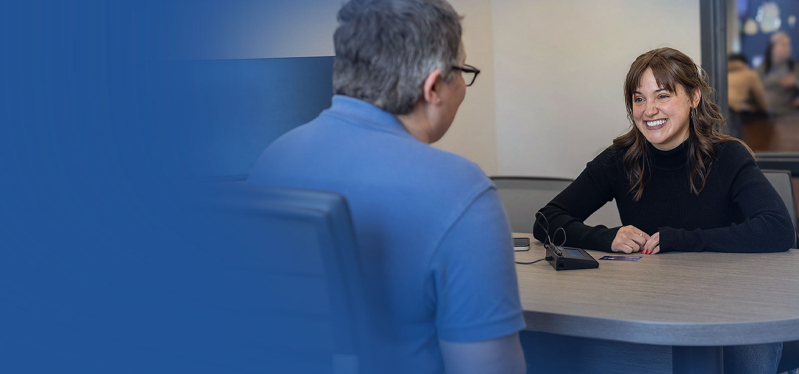 Woman working with Credit Counseling Services at a desk at an RCU Office