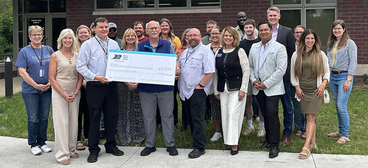 Group of RCU leaders and WDEOC leaders holding a check in front of the building