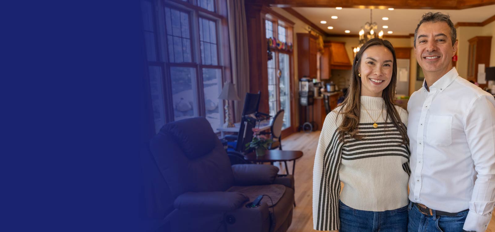 Couple standing in a cozy kitchen-living room with casual attire