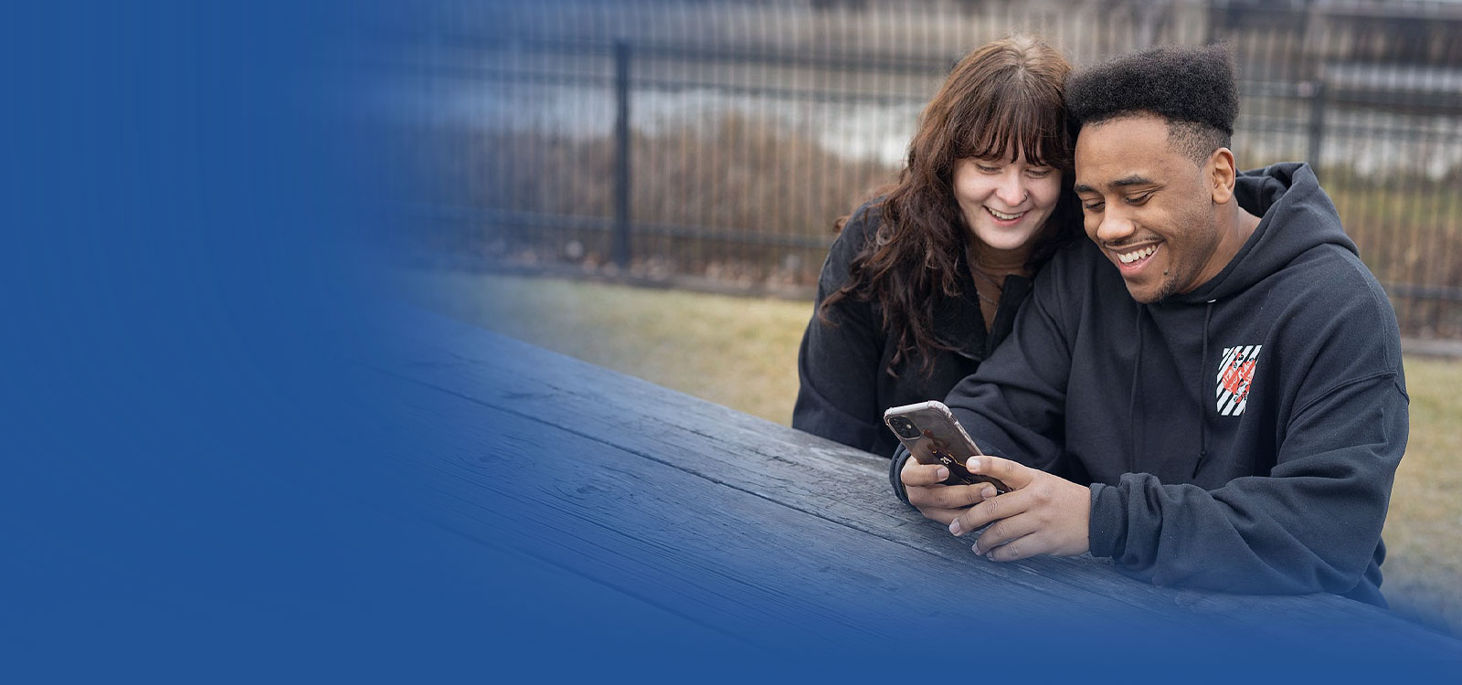 Young couple looking happily at their mobile banking application