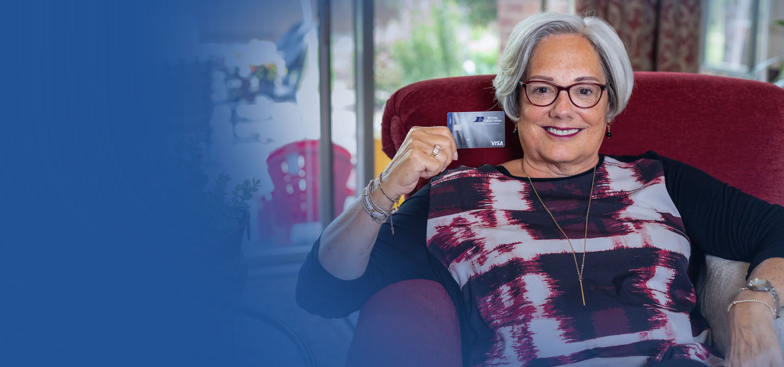 Woman sitting in a chair holding an RCU Debit Card
