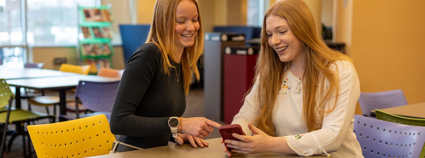 Two young people looking at a mobile phone