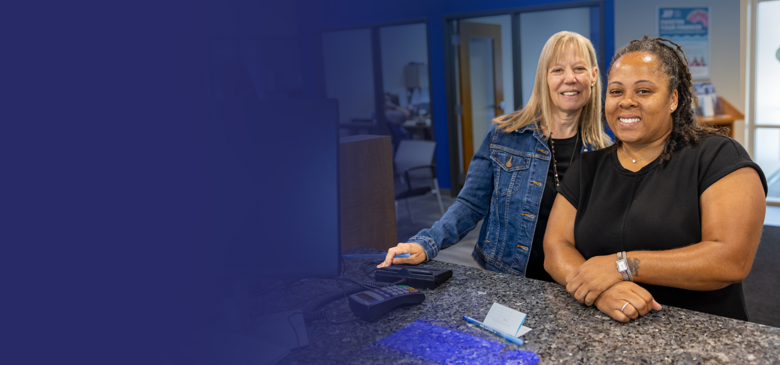 Photo of women standing at a counter in a Royal Office