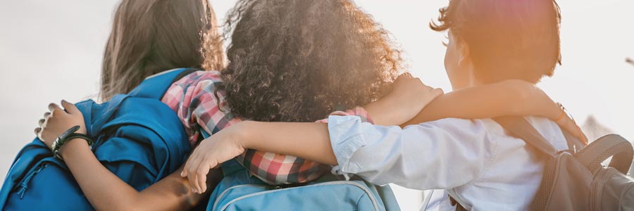 Kids hugging with backpacks