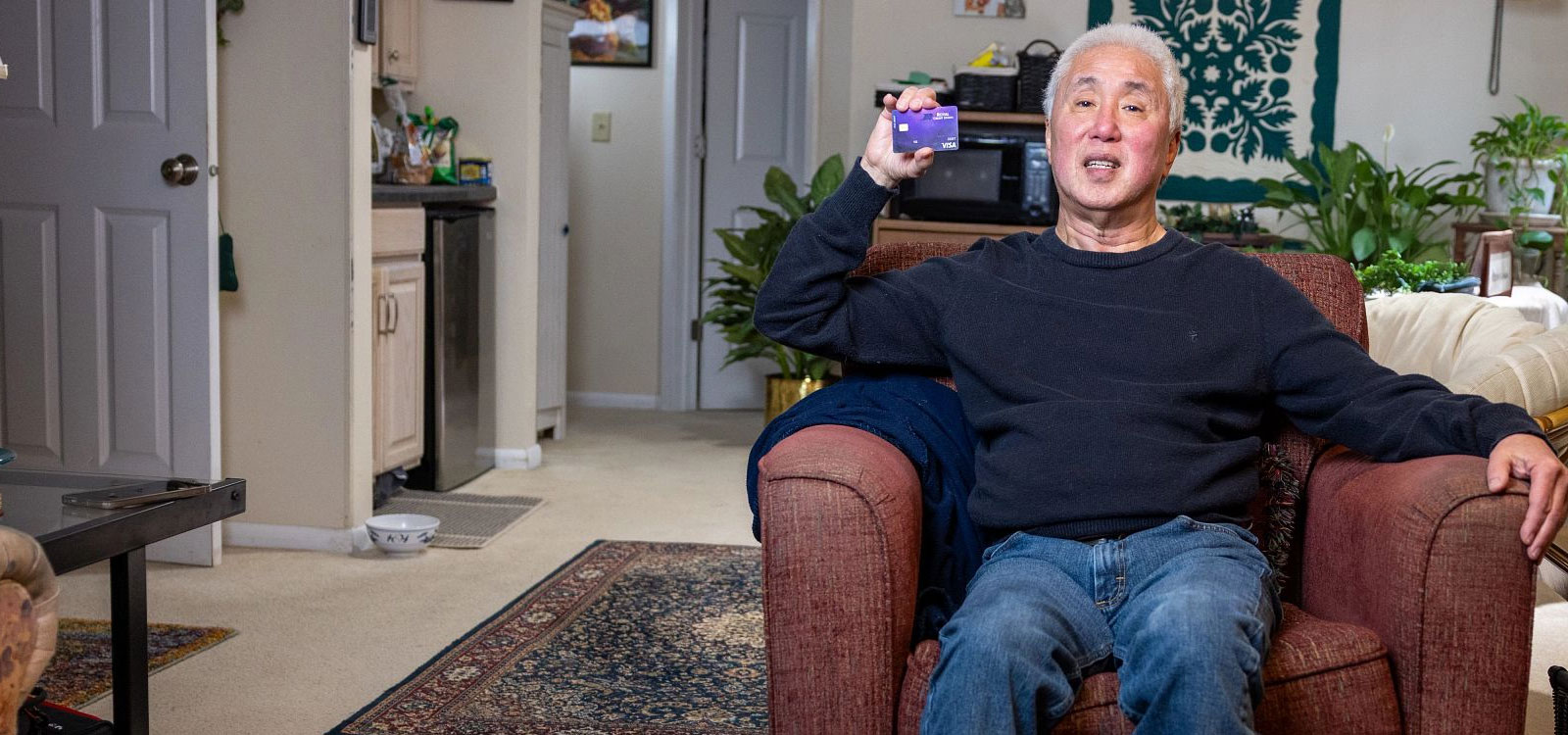 Member sitting in chair holding an HSA card