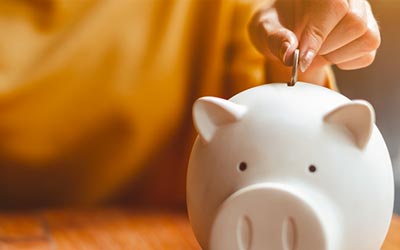 Woman putting money into a piggy bank