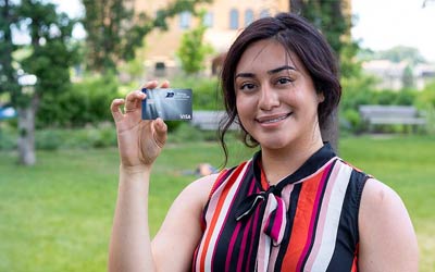 Young woman holding a Royal Rewards Visa card