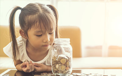 Child looking at savings jar