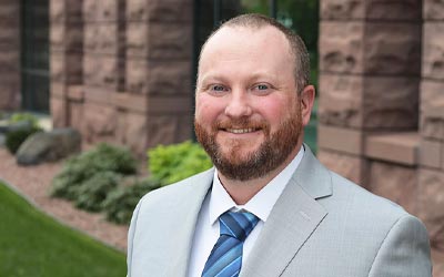 team member photo standing near building and smiling