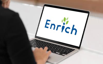Person working on laptop with Enrich logo