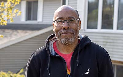 Man standing in front of his house