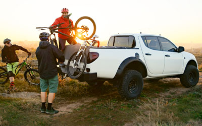 mountain bikers loading bikes into a white truck