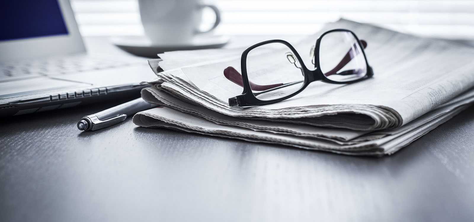 Glasses, computer and newspaper