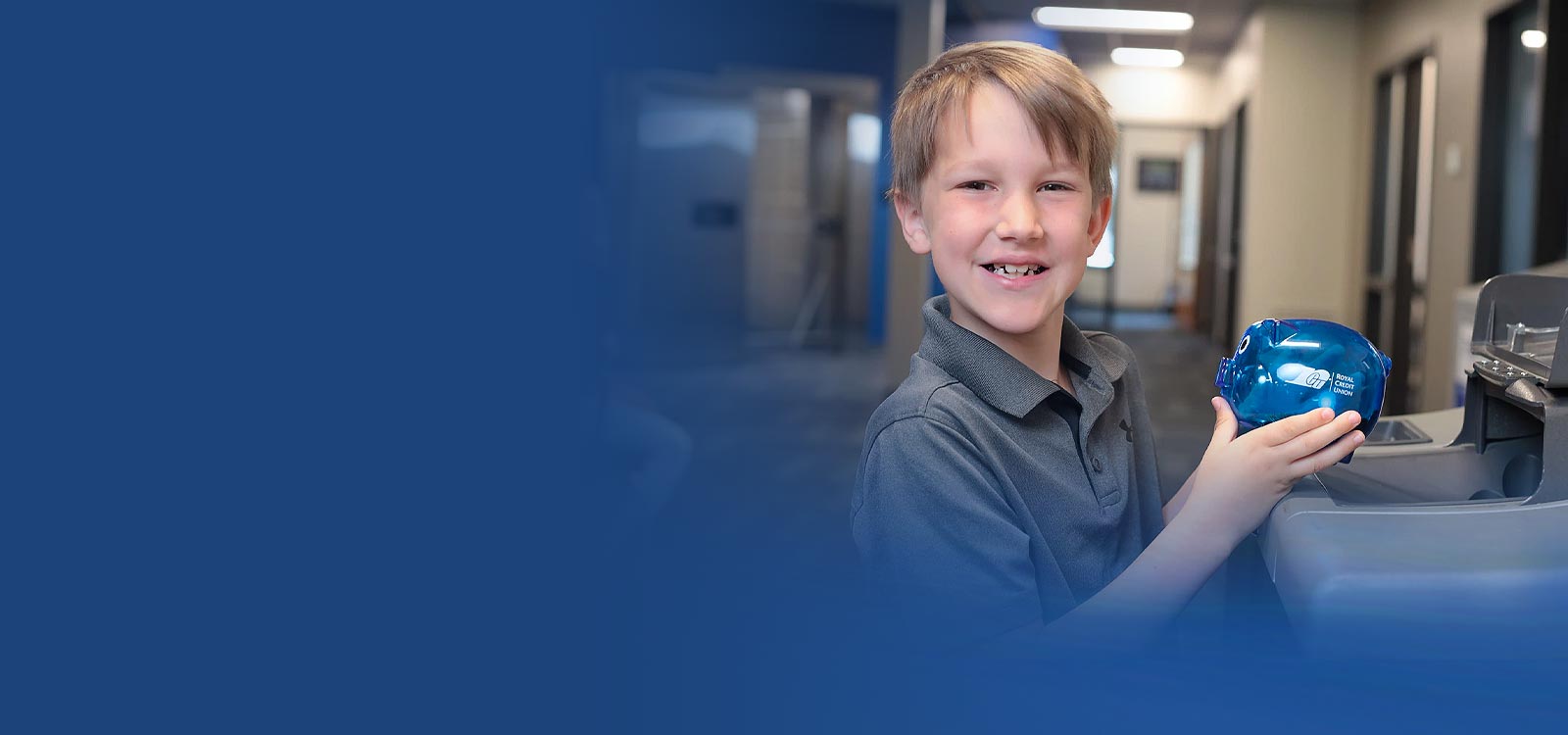 Child depositing coins from a blue piggy bank