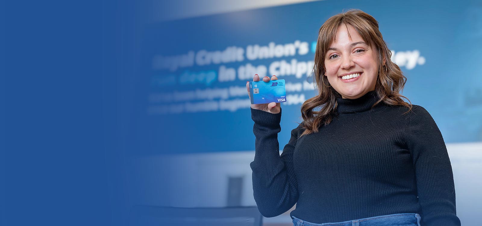 Royal Credit Union Member holding a debit card
