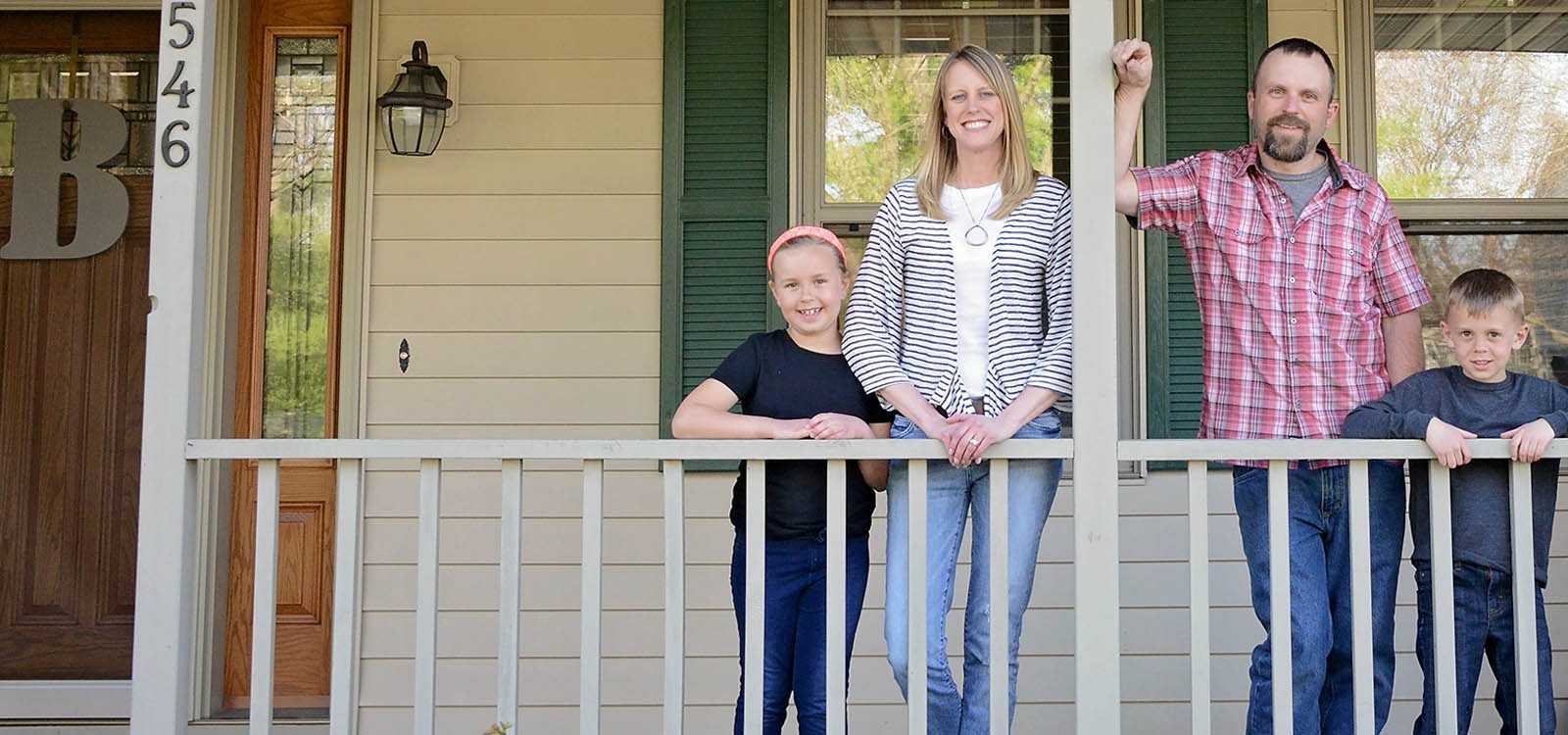 happy family on porch of new home