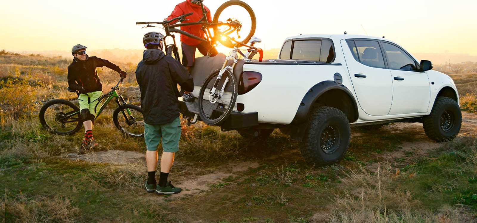 Mountain bikers loading bikes into a white truck