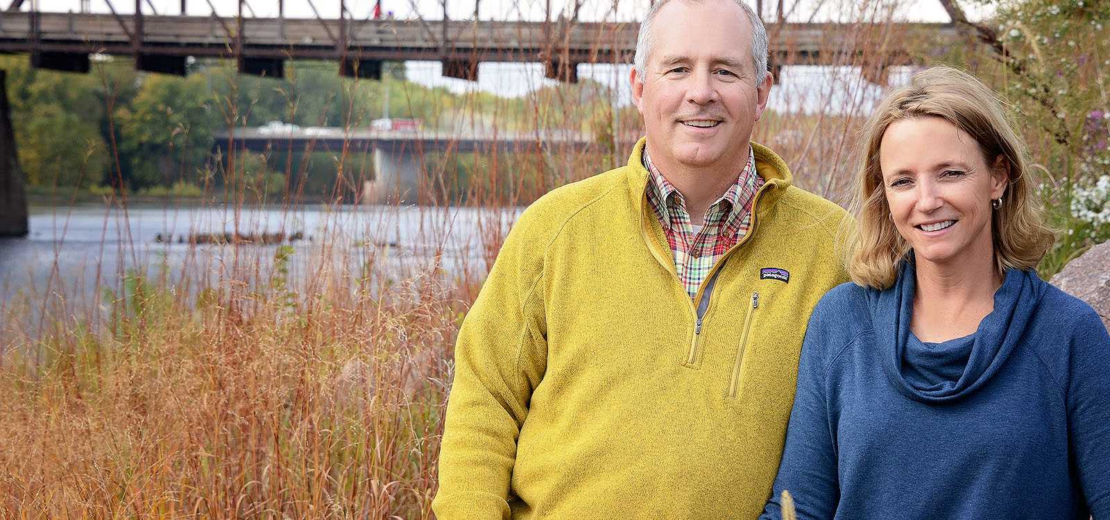 Empty nest couple in front of bridge