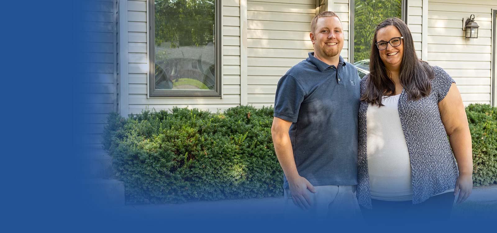 Happy Royal couple standing in front of house