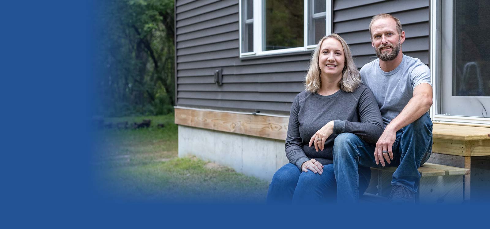 Couple sitting in front of new home