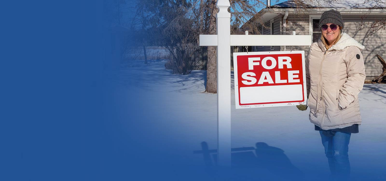 Woman standing in front of for sale sign
